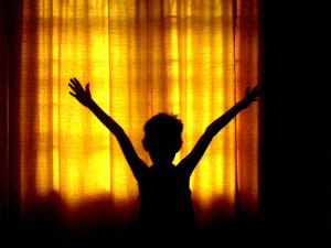 boy in shadows leaping for joy